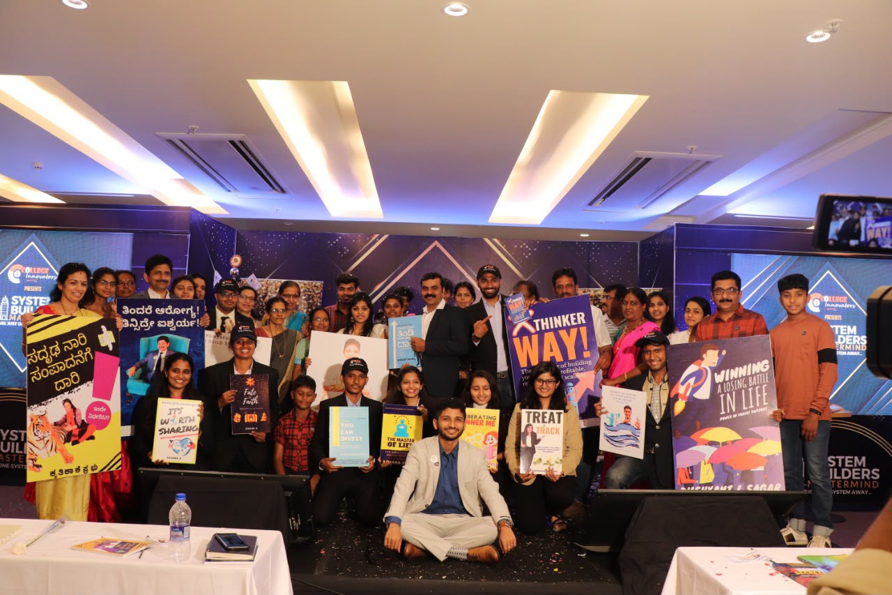 Members on stage holding their published books at the CI MAP live event